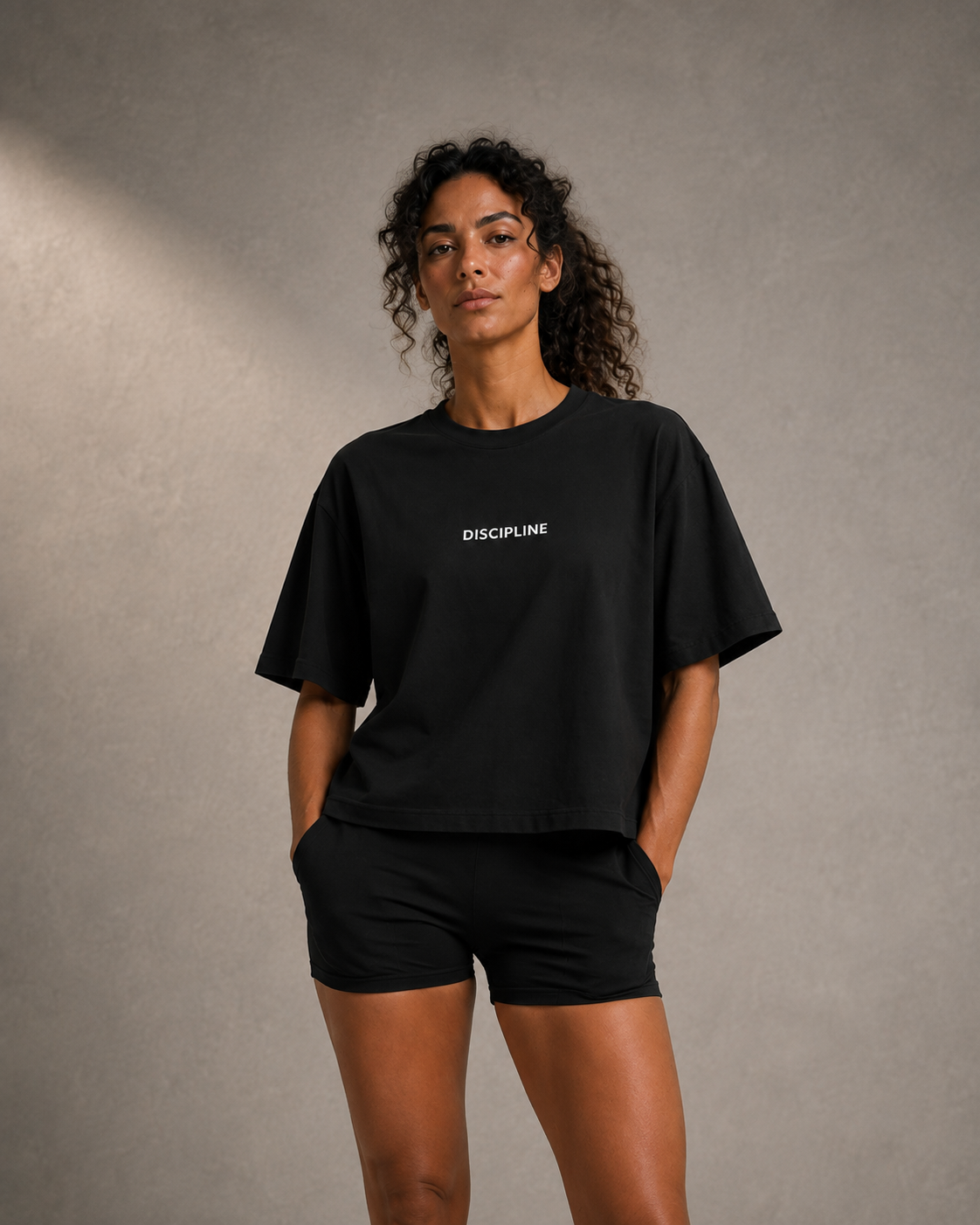 Maya wearing the DISCIPLINE boxy tee in black, close crop at the chest